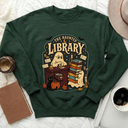 Green sweatshirt with "The Haunted Library" graphic featuring ghosts, books, a black cat, and a pumpkin.