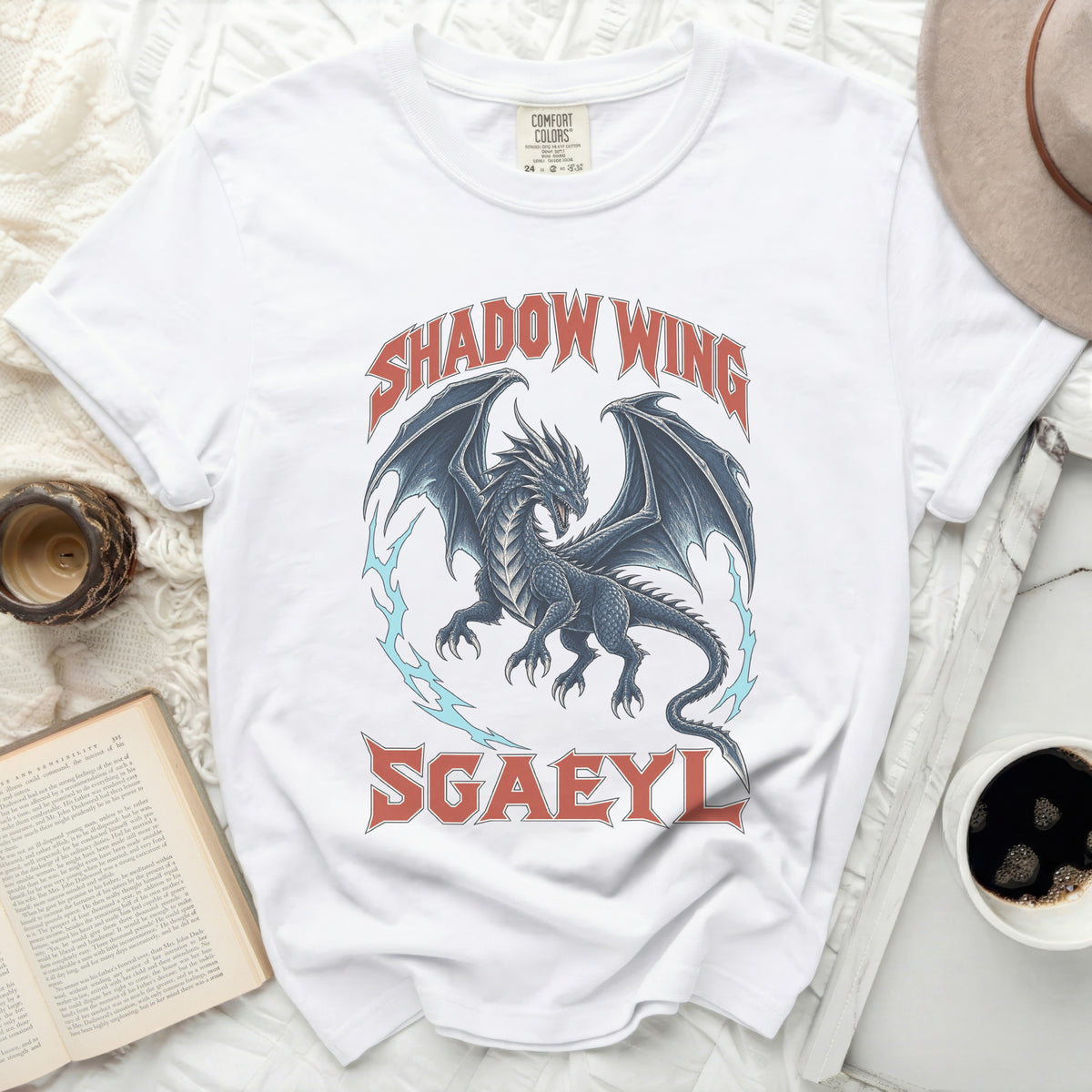 A white t-shirt featuring a blue dragon graphic with red text reading Shadow Wing and Sgaeyl.