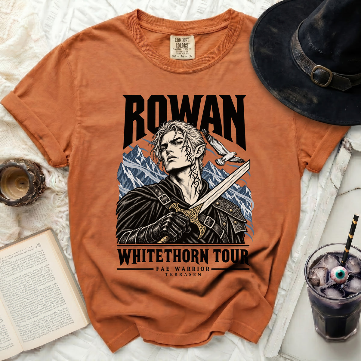Orange t-shirt with Rowan, Fae Warrior, and Whithorn Tour graphic.