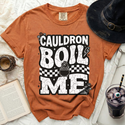 Orange t-shirt with "Cauldron Boil Me" Halloween graphic.