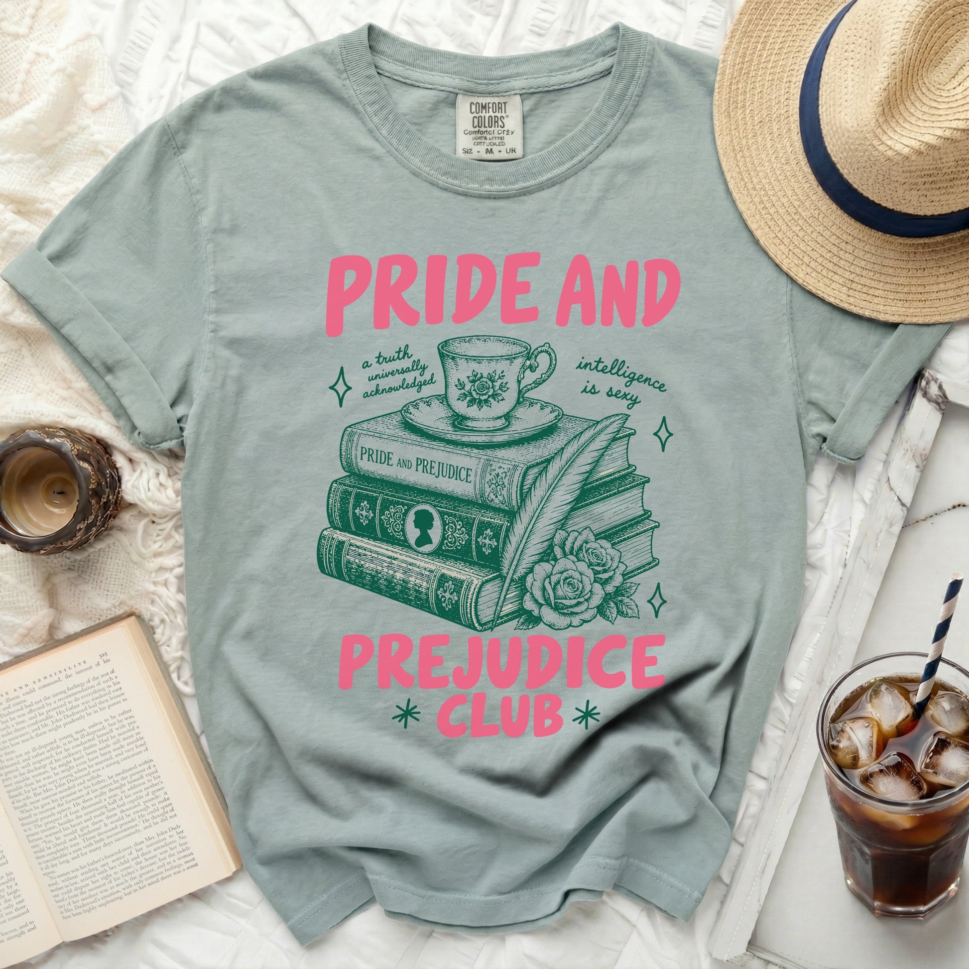 Pink text "Pride and Prejudice Club" on a sage green t-shirt with book illustration.