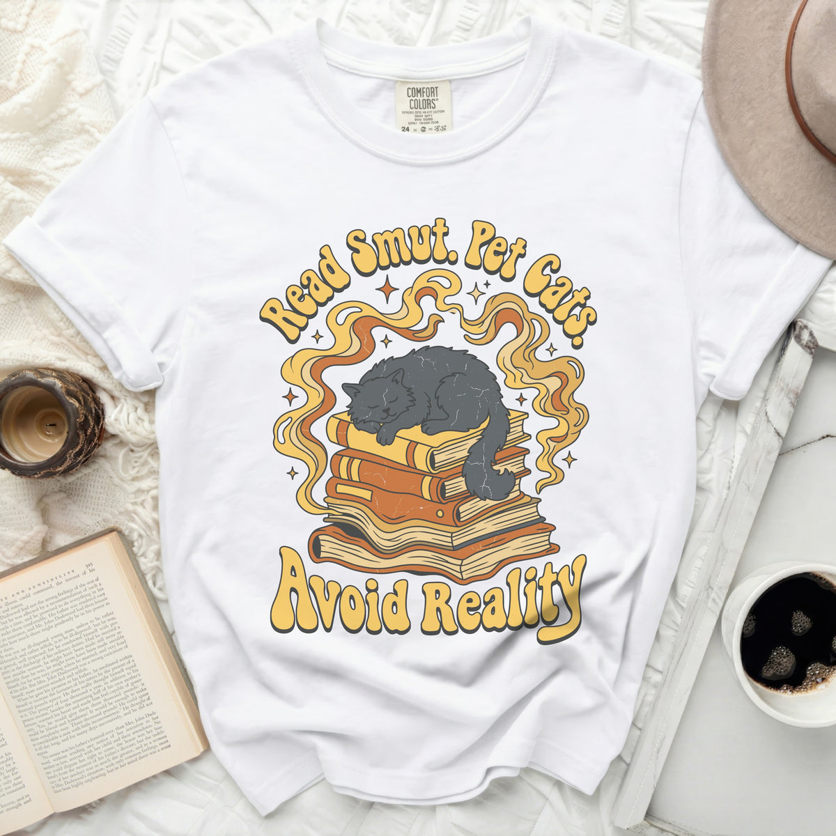White t-shirt with "Read Smut. Pet Cats. Avoid Reality." text and cat on books.