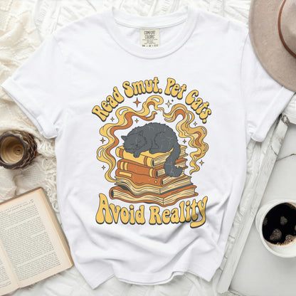 White t-shirt with "Read Smut. Pet Cats. Avoid Reality." text and cat on books.