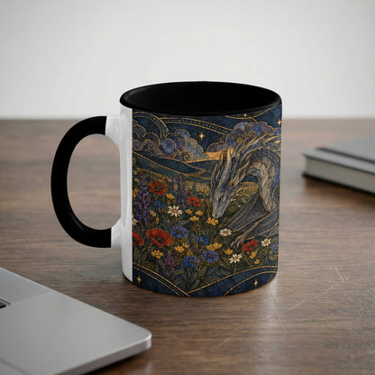 A white mug with a black handle and interior features a stained-glass-style illustration of a dragon in a field of colorful wildflowers.
