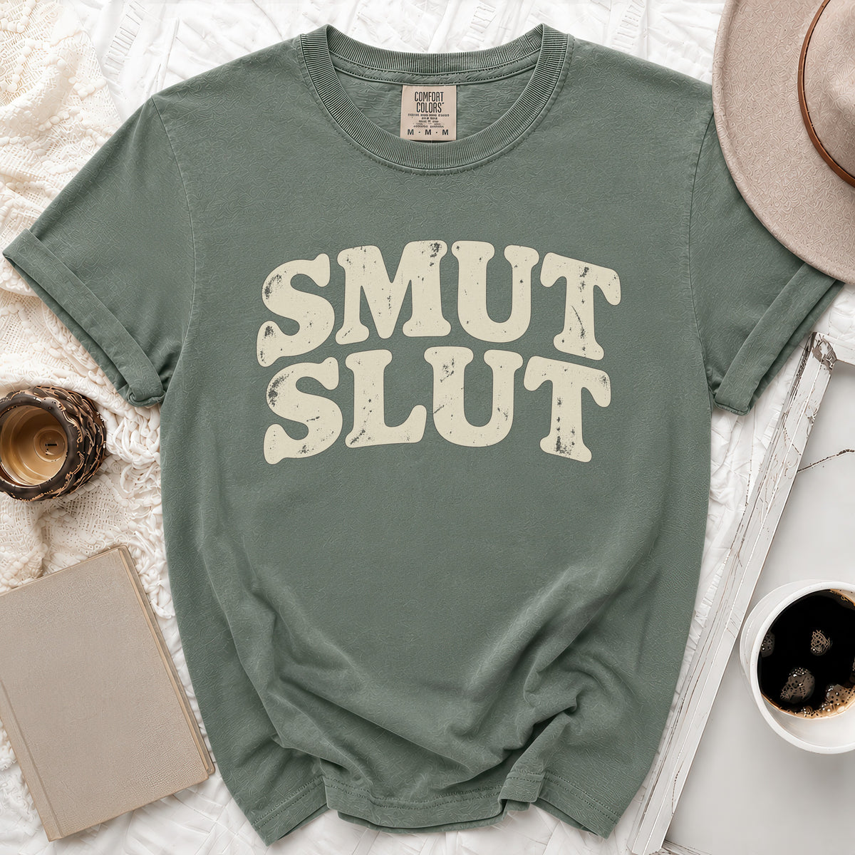 Green t-shirt with "SMUT SLUT" text in distressed cream lettering.