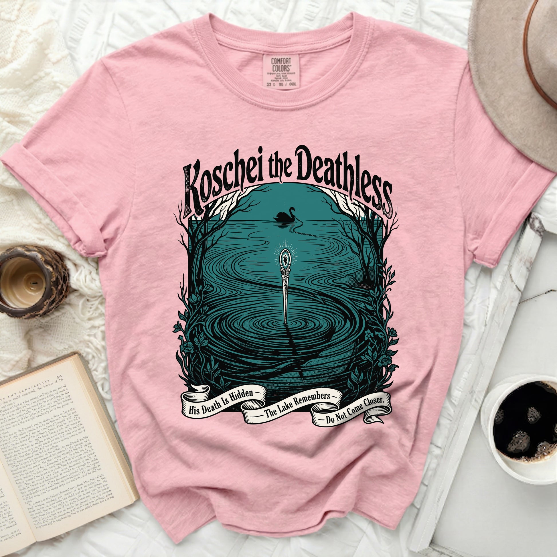 Pink t-shirt with "Koschei the Deathless" and lake imagery with text.