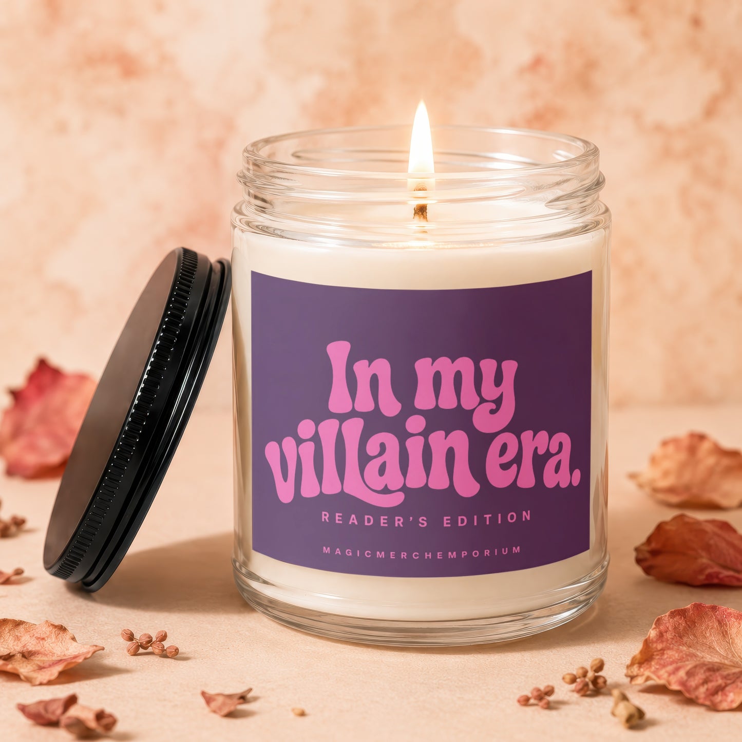 Candle with lit wick on purple label reading "In my villain era. Reader's Edition".