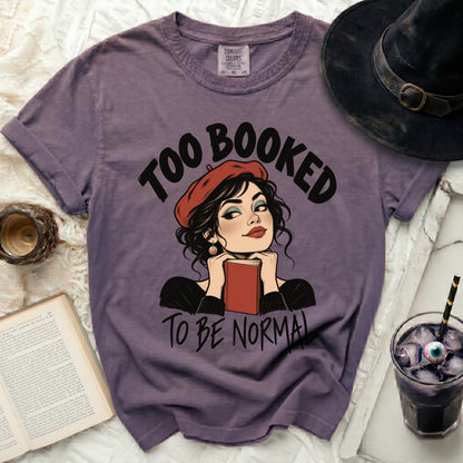 Purple t-shirt with "Too Booked to Be Normal" text and illustration.