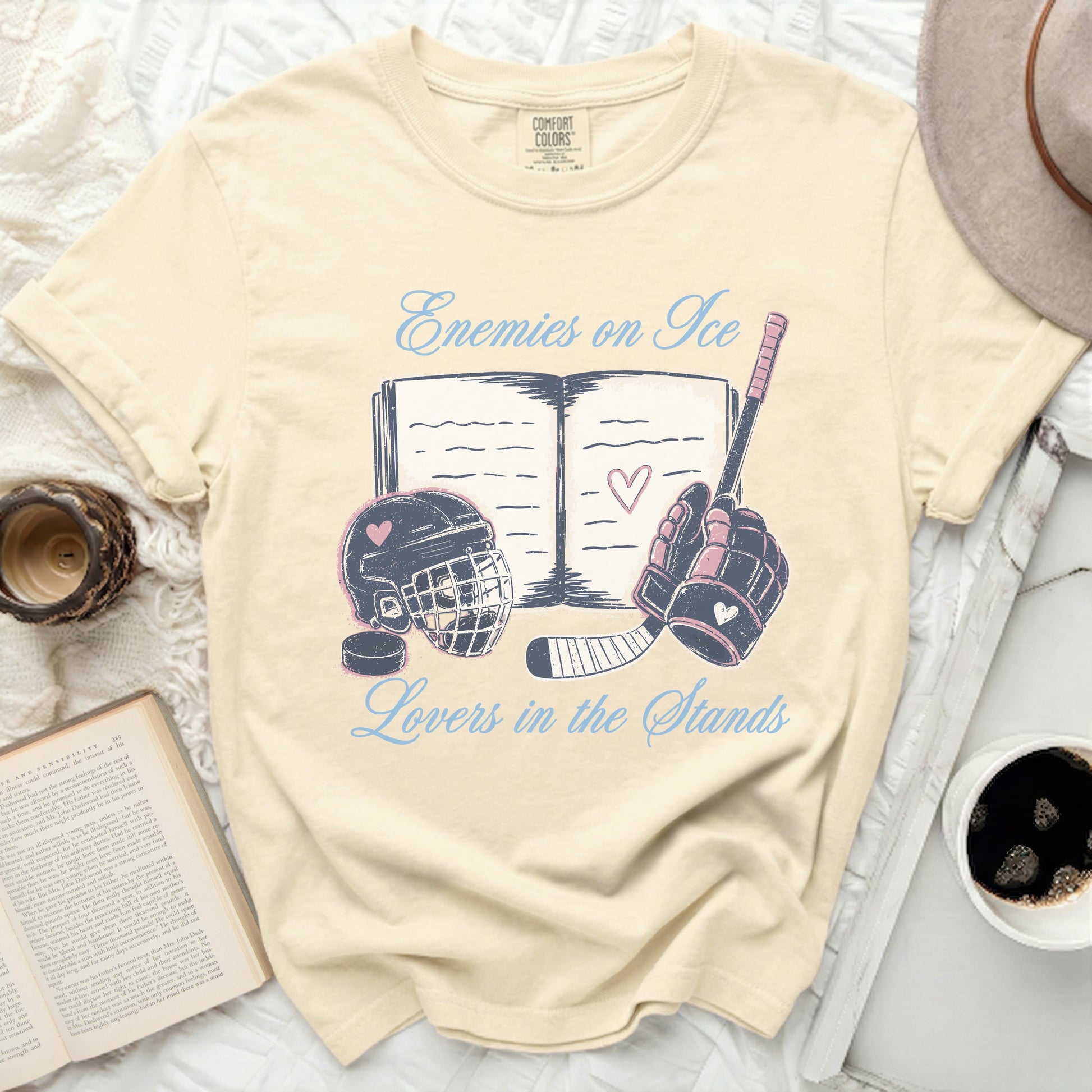 Cream t-shirt with "Enemies on Ice Lovers in the Stands" text and hockey graphics.