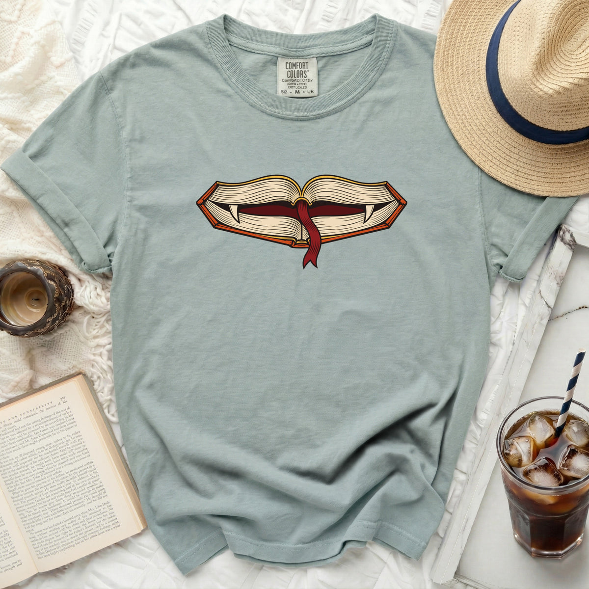Light blue t-shirt with open book graphic featuring vampire fangs and red ribbon.