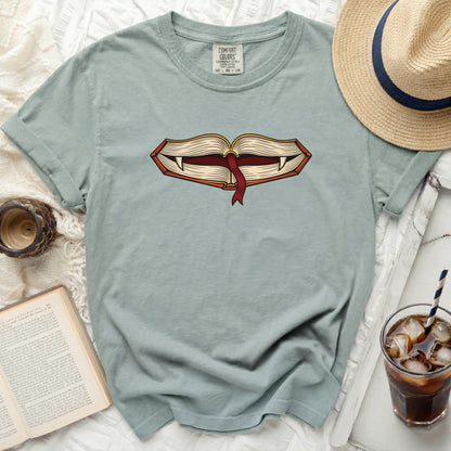 Light blue t-shirt with open book graphic featuring vampire fangs and red ribbon.