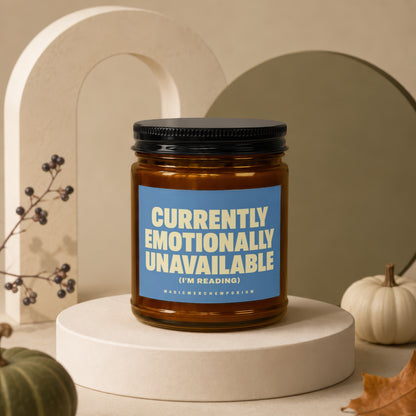 Amber glass candle with blue label reading "Currently Emotionally Unavailable (I'm Reading)".