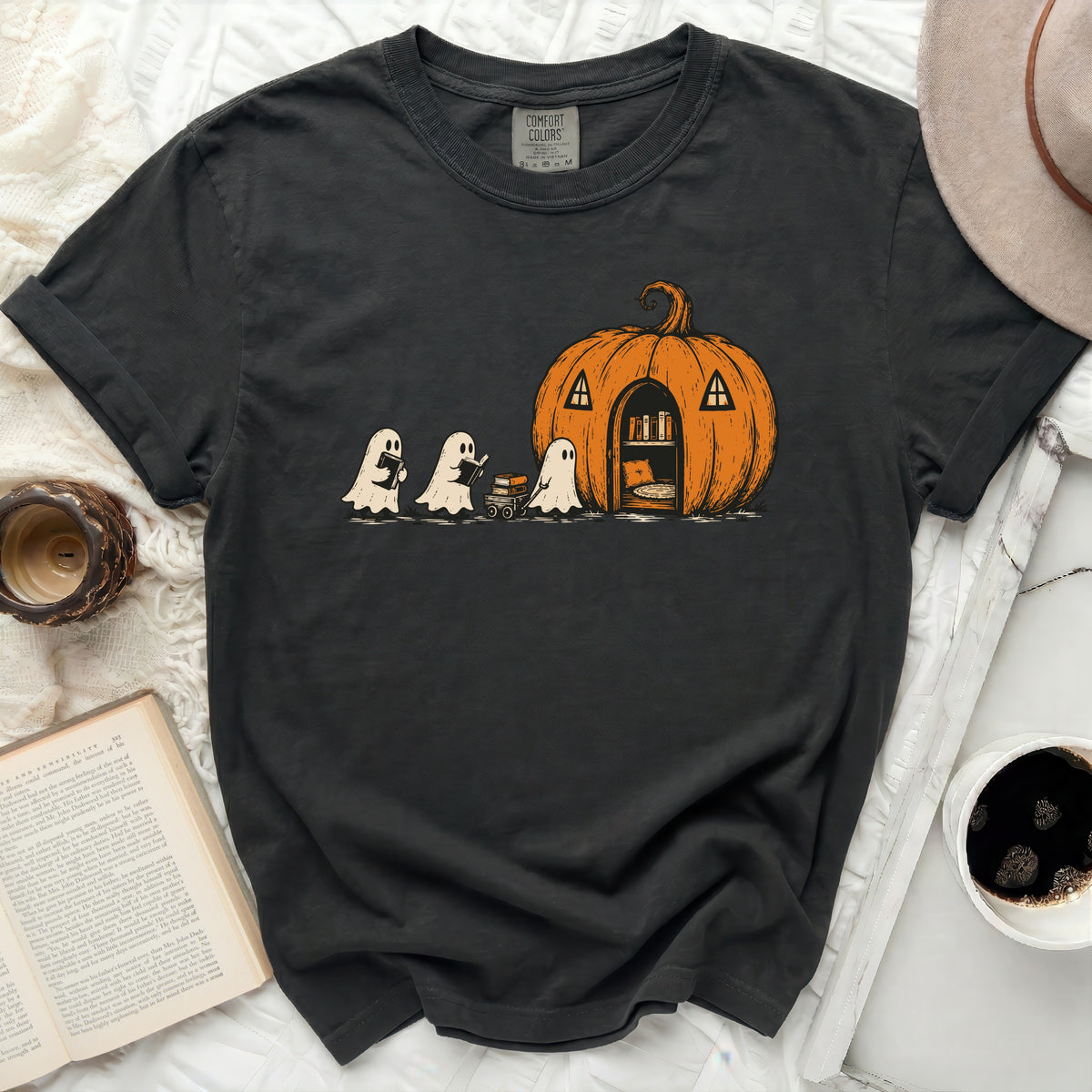 Three ghosts walk towards a pumpkin house with books and a cart.