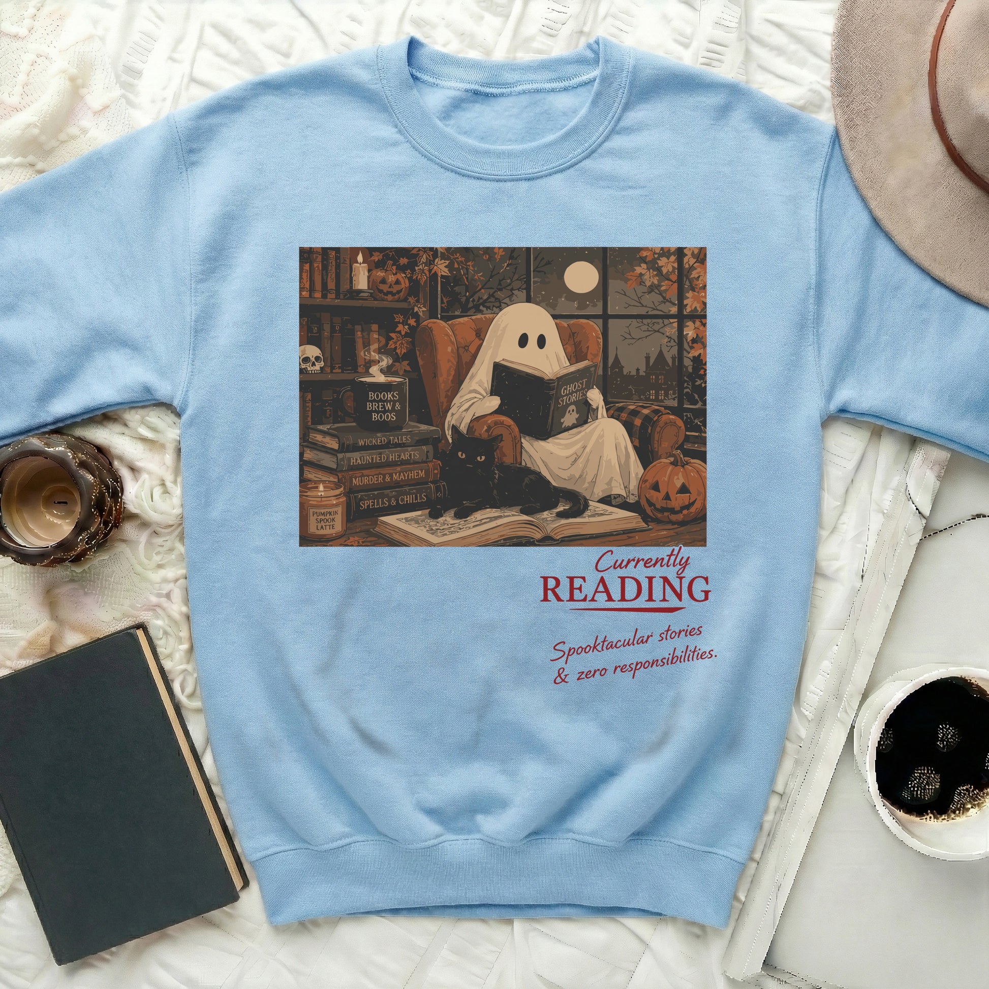 Light blue sweatshirt with graphic of ghost reading a book, black cat, and text.