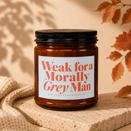 Amber jar candle with white label reading "Weak for a Morally Grey Man".