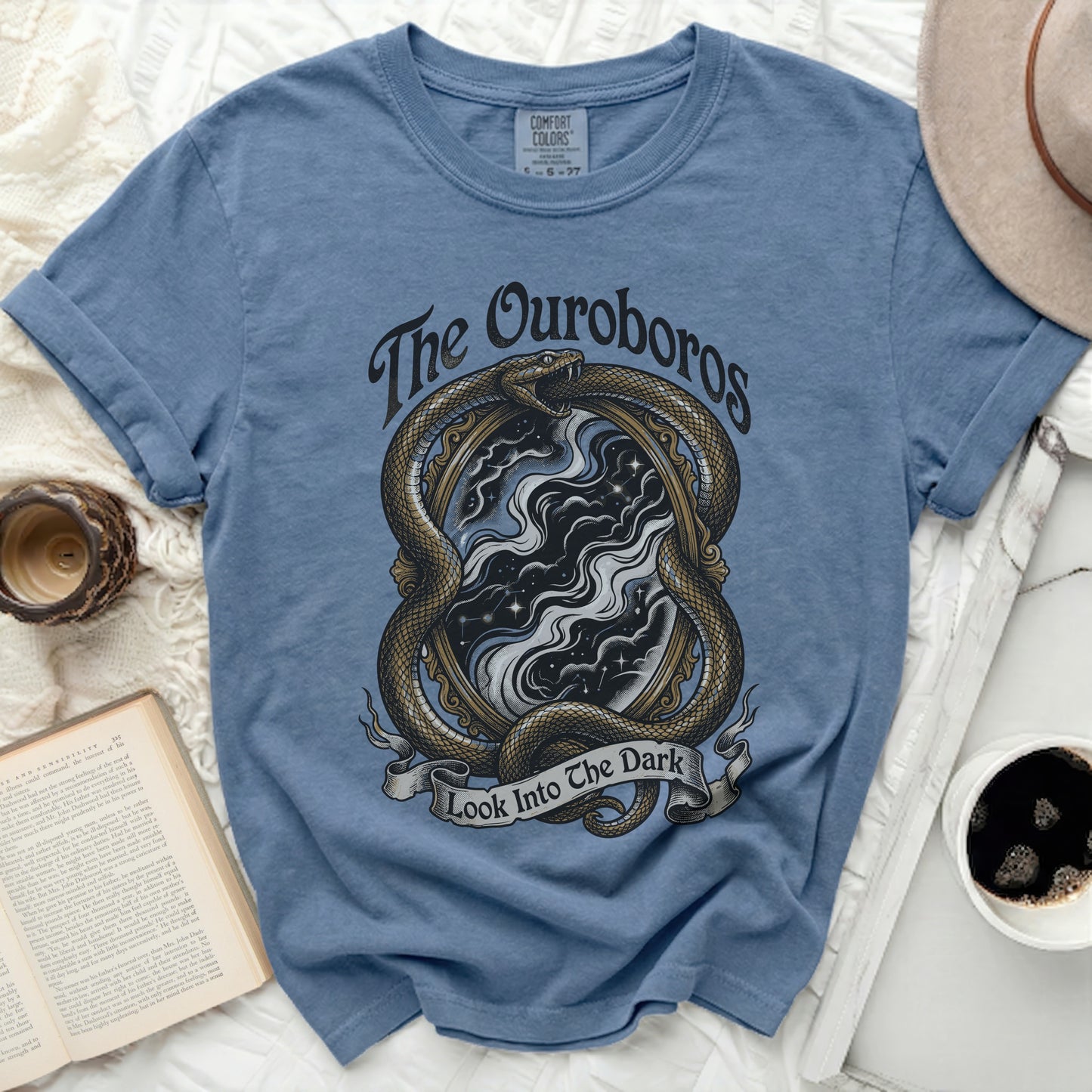Blue t-shirt with Ouroboros snake, mirror, stars, and text "The Ouroboros Look Into The Dark".