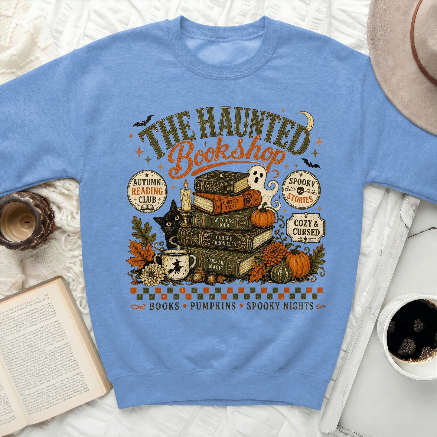 Sweatshirt with "The Haunted Bookshop" graphic featuring books, ghost, black cat, and pumpkins.
