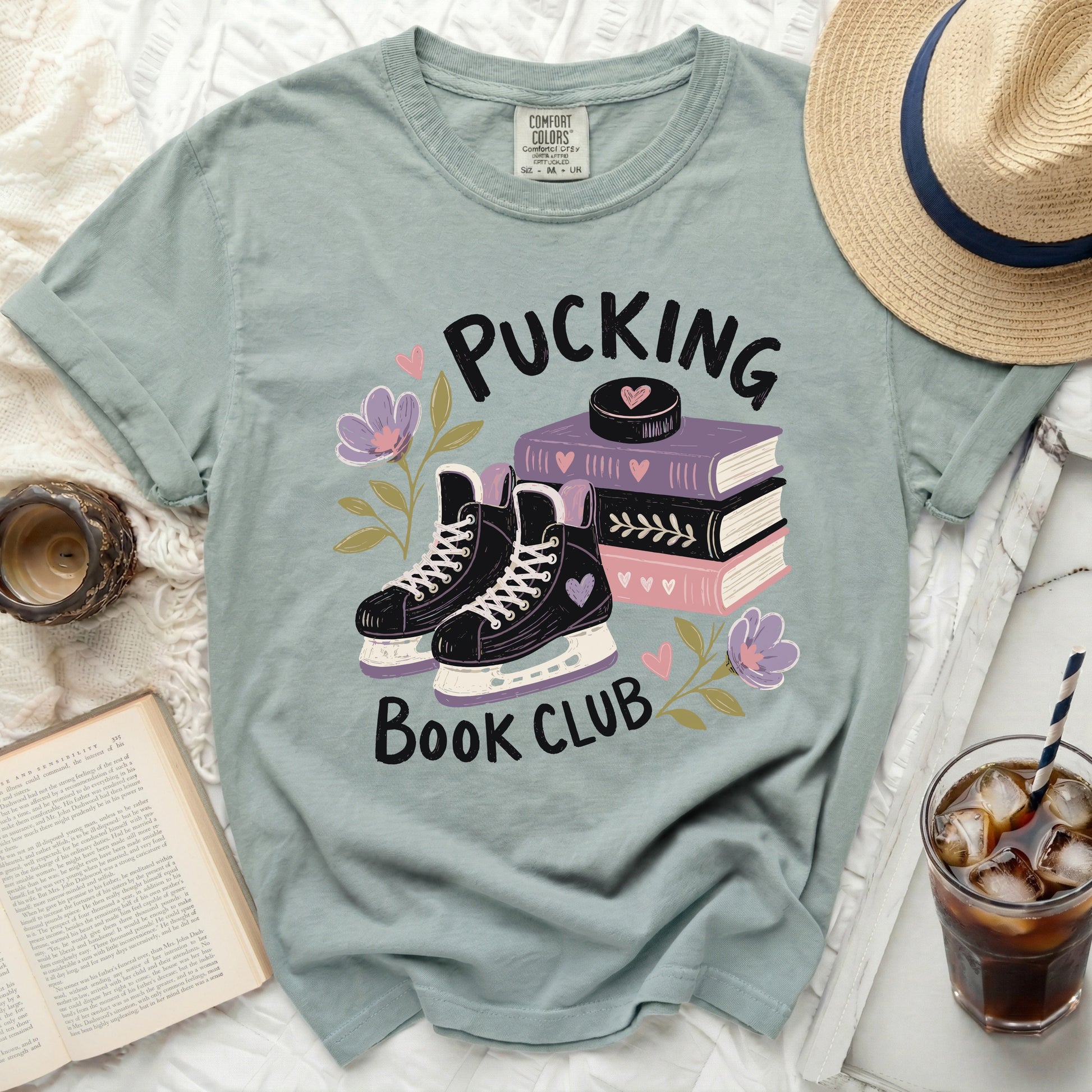 T-shirt with ice skates, books, and "Pucking Book Club" text.