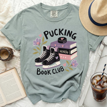 T-shirt with ice skates, books, and "Pucking Book Club" text.