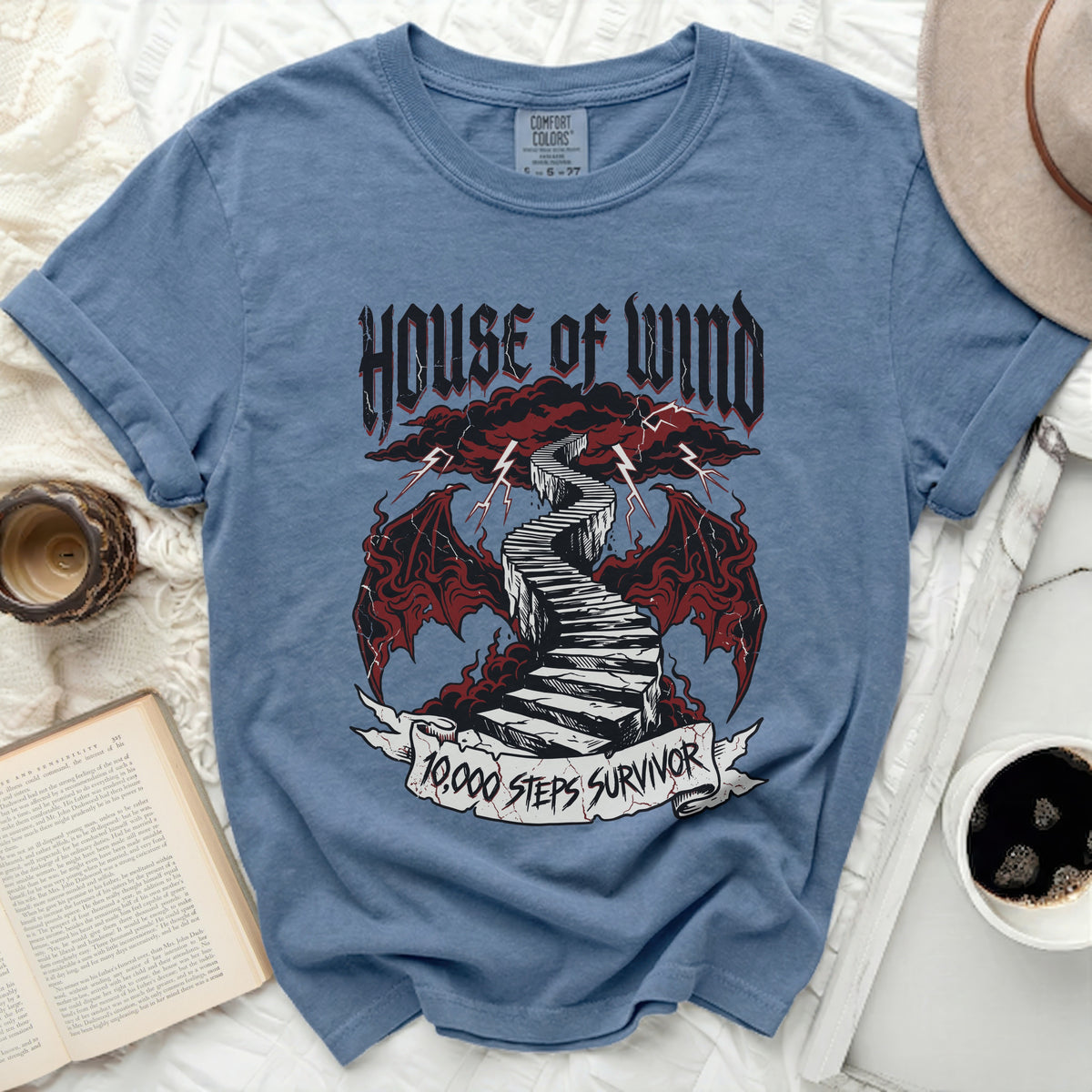 Blue t-shirt with "House of Wind 10,000 Steps Survivor" graphic.