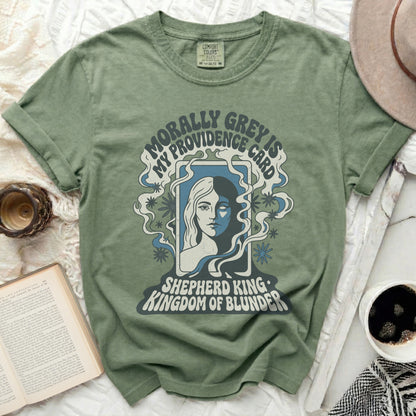 Green t-shirt with "Morally Grey Is My Providence Card Shepherd King Kingdom Of Blunder" text.
