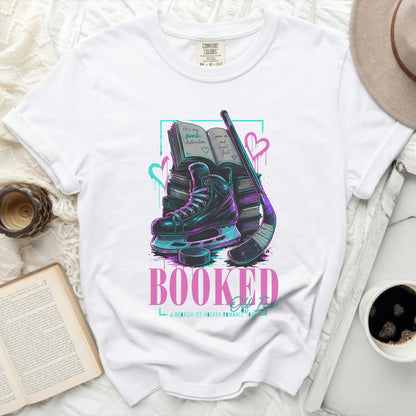 White t-shirt with "Booked" text, ice skates, books, and hockey stick.