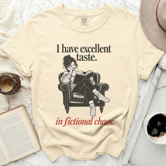 Cream t-shirt with "I have excellent taste. in fictional chaos." text and illustration.