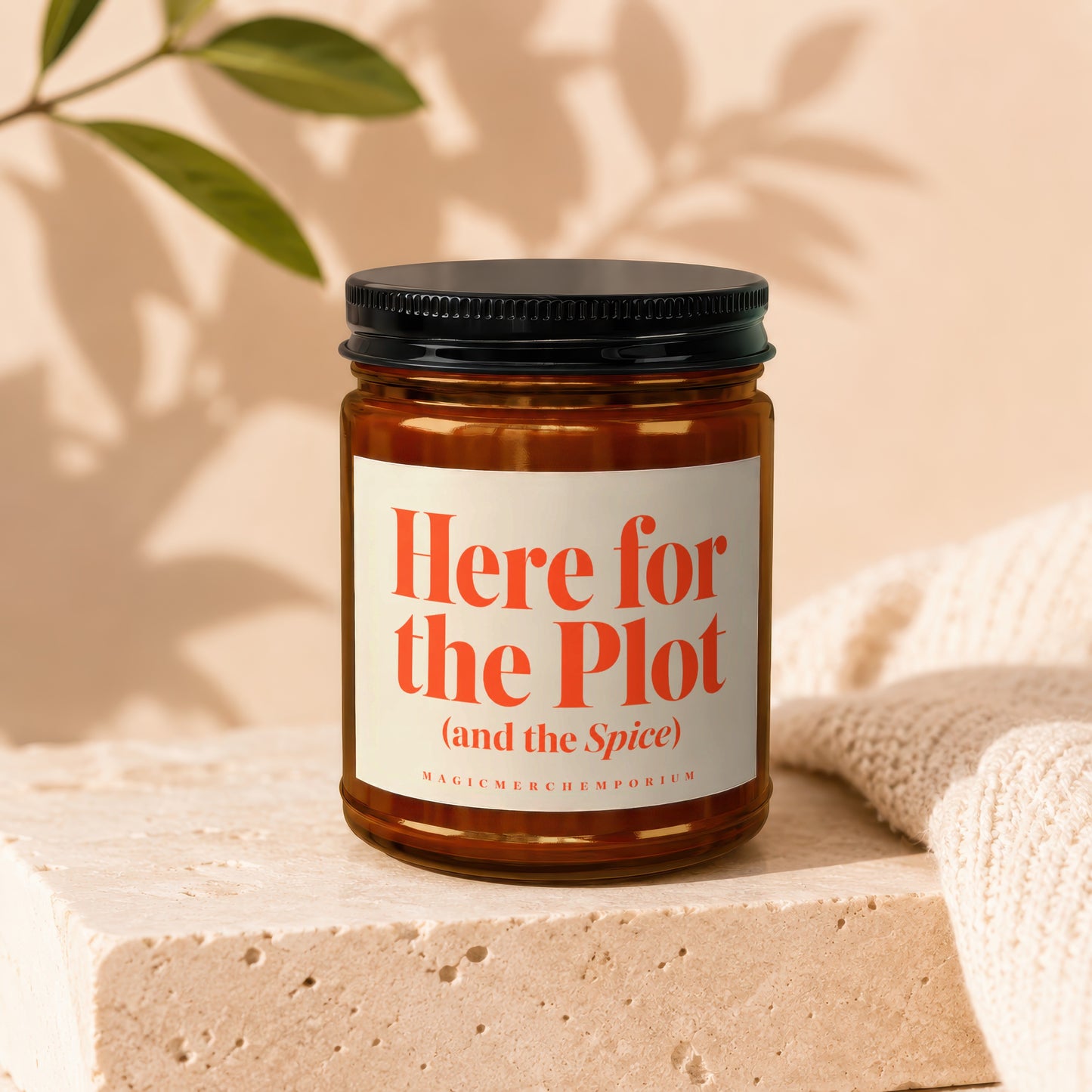 Amber glass candle with orange text "Here for the Plot (and the Spice)".