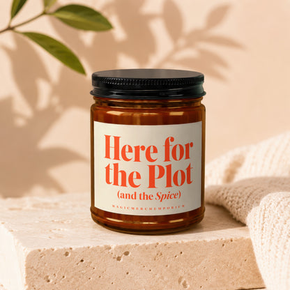 Amber glass candle with orange text "Here for the Plot (and the Spice)".
