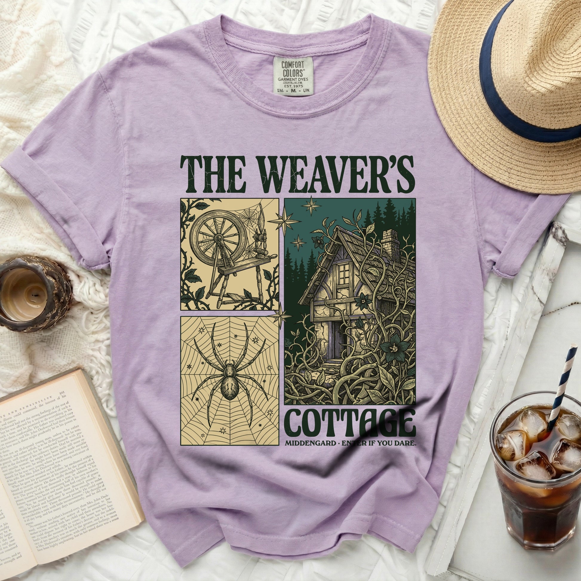 The Weaver's Cottage t-shirt features a graphic with a spinning wheel, spider, and cottage.