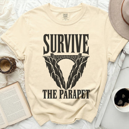 Cream t-shirt with "SURVIVE THE PARAPET" graphic featuring a bridge and cliff design.