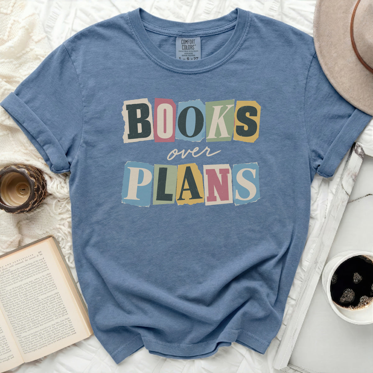 Blue t-shirt with torn letter graphic saying "BOOKS over PLANS".