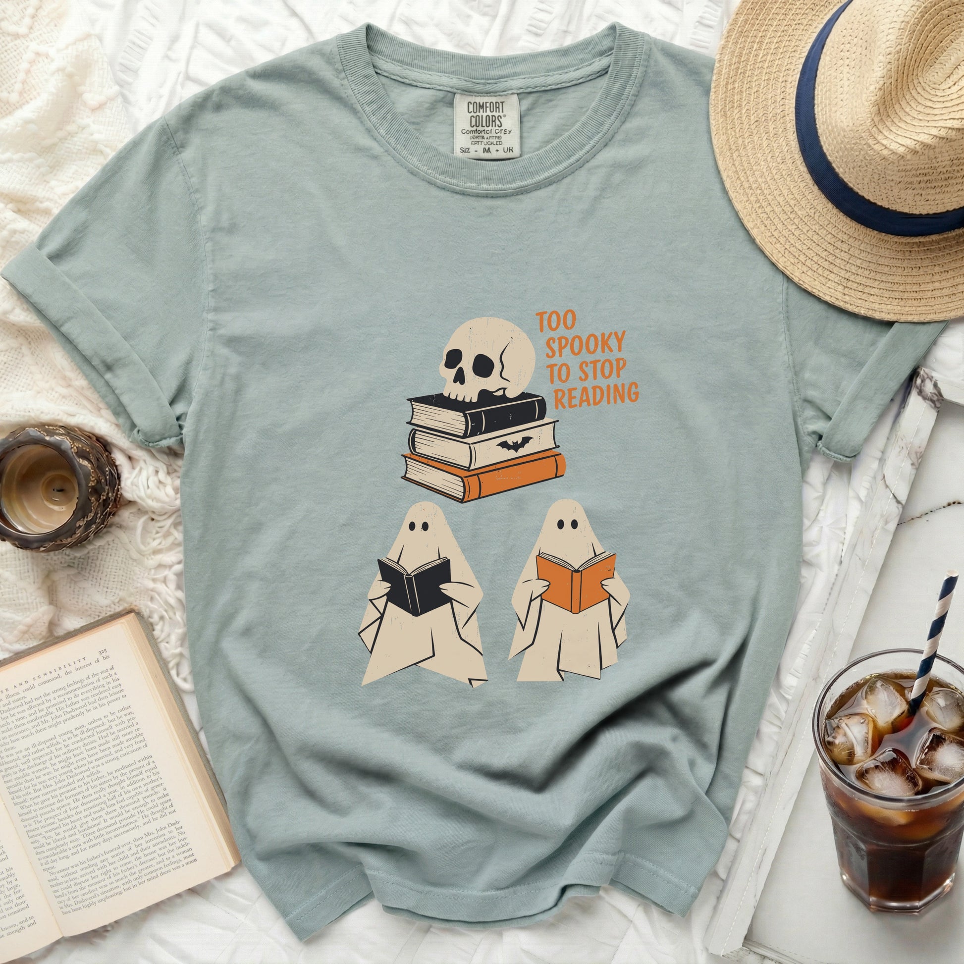 Two ghosts read books next to a skull on books with "Too Spooky to Stop Reading" text.