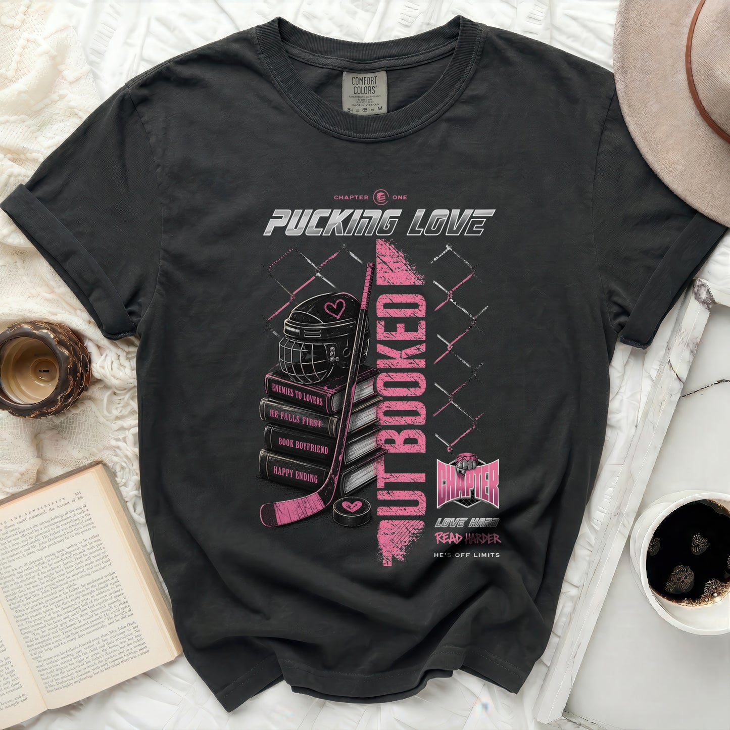 Black t-shirt with "Pucking Love" graphic featuring a hockey puck, helmet, and book titles.