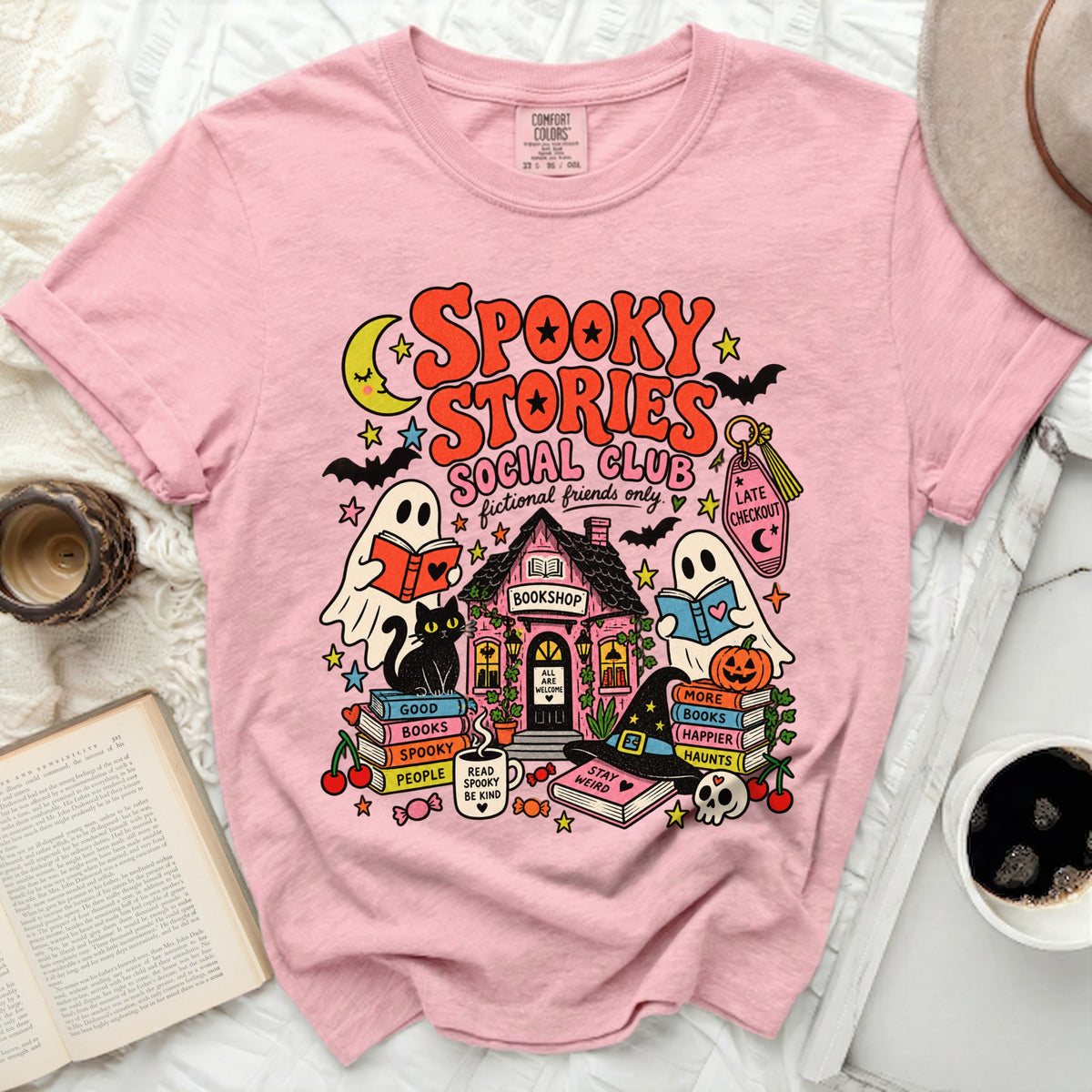 Pink t-shirt with "Spooky Stories Social Club" graphic and Halloween bookshop scene.