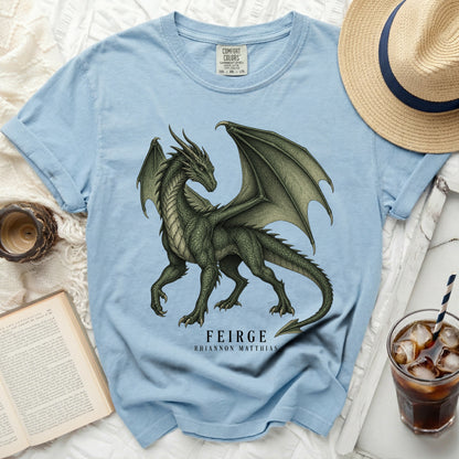 Light blue t-shirt with a green dragon graphic and text "FEIRGE RHIANNON MATTHIAS".