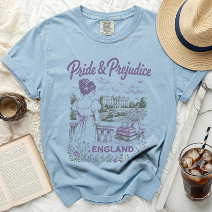 Blue t-shirt with "Pride & Prejudice" text and an illustration of a woman overlooking a manor.