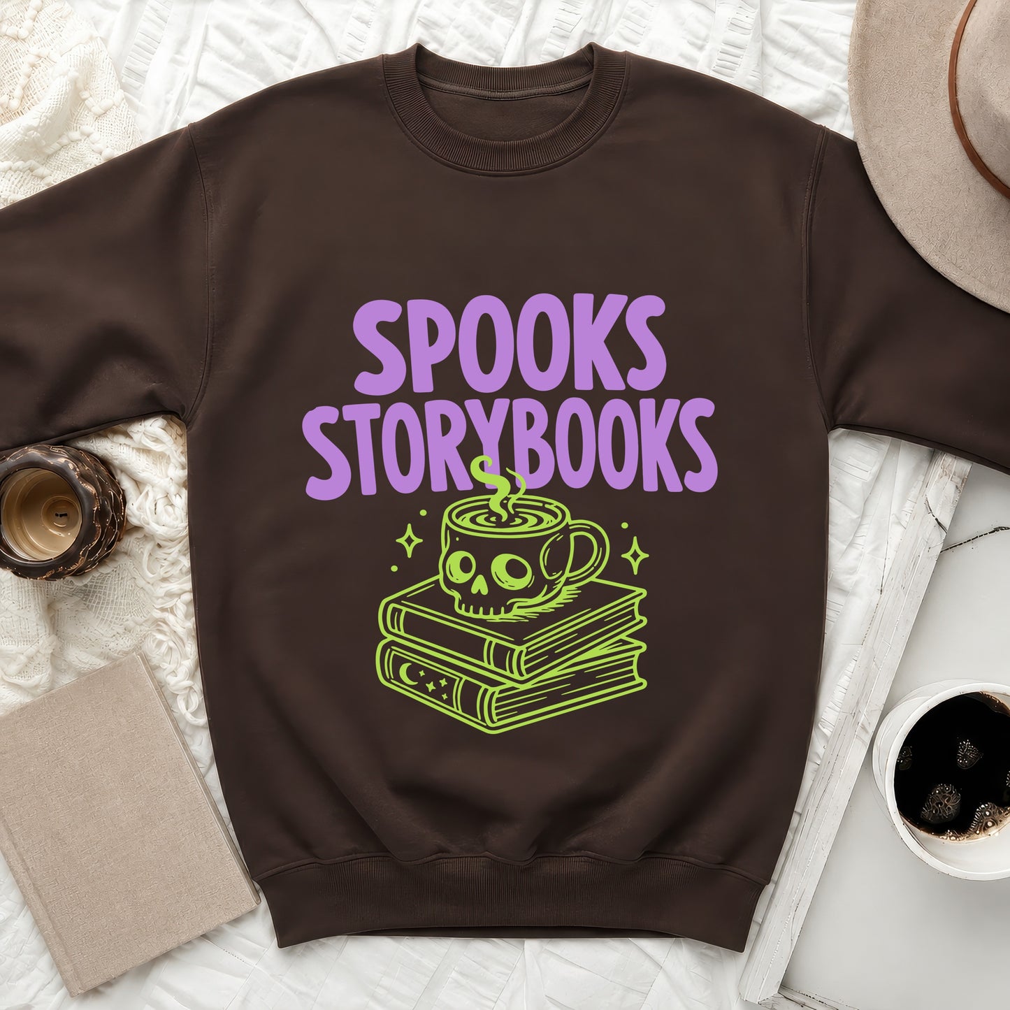 Brown sweatshirt with purple "SPOOKS STORYBOOKS" text and green skull mug art.
