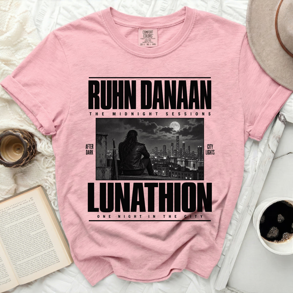 Pink t-shirt with "RUHN DANAAN LUNATHION" graphic and city skyline.