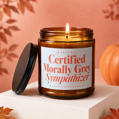 Amber jar candle with lit wick, lid askew, reads "Certified Morally Grey Sympathizer".