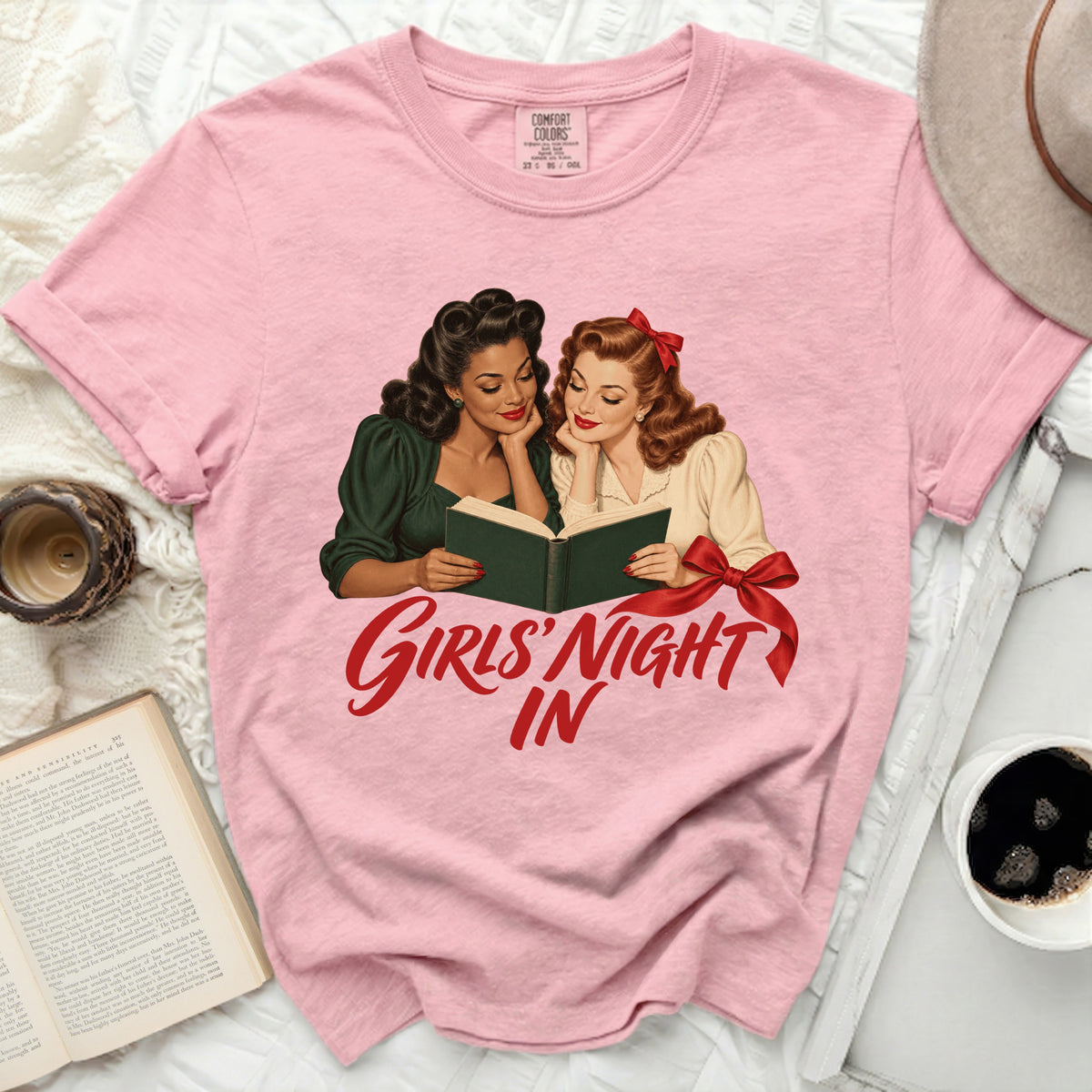 Pink t-shirt with retro illustration of two women reading and text "Girls' Night In".