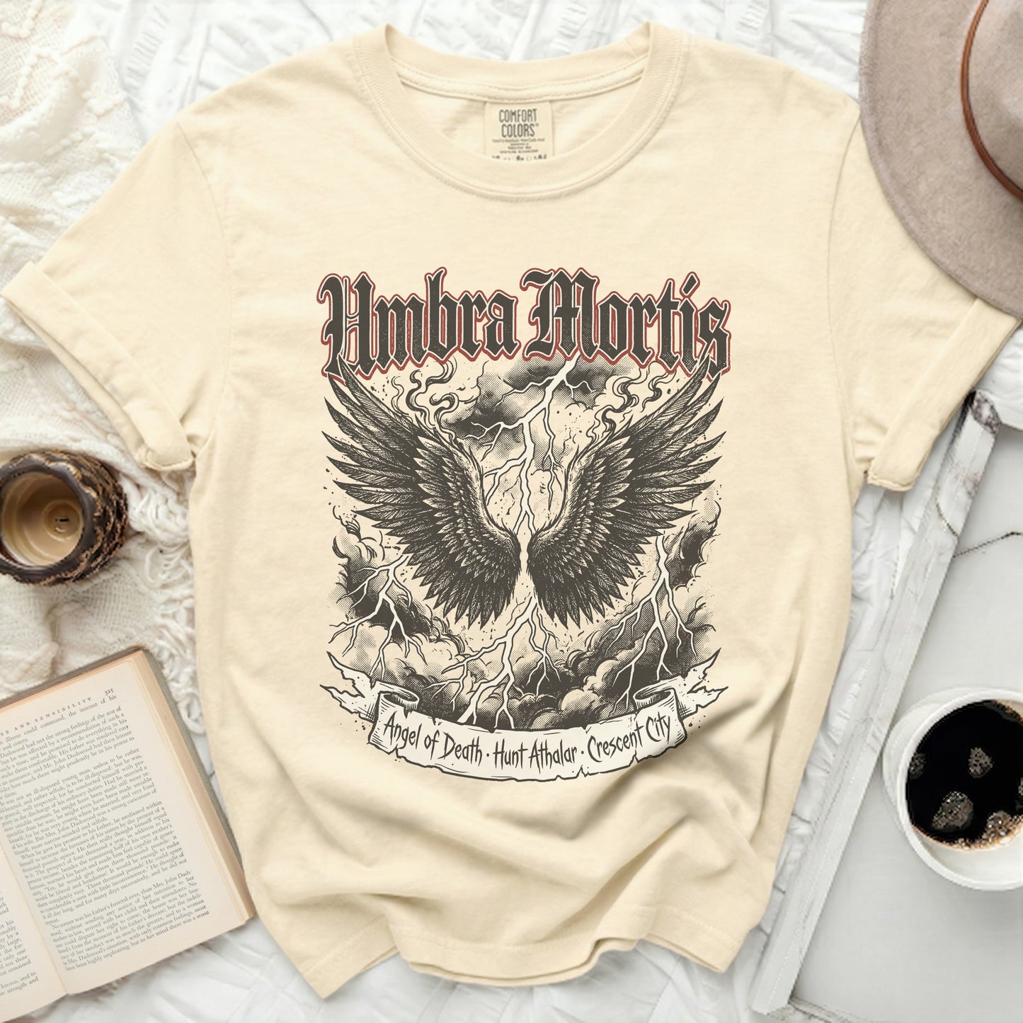 Cream t-shirt with black winged skull and text "Umbra Mortis".