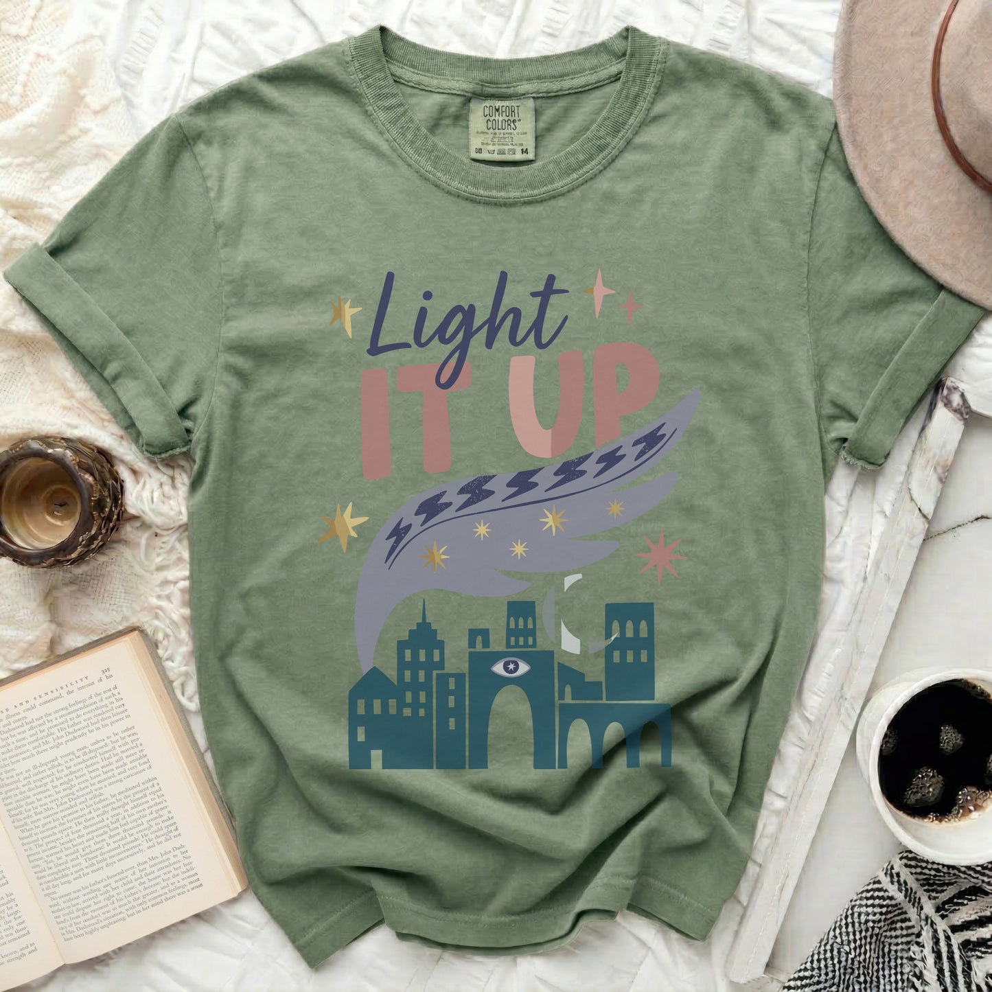 Green t-shirt with "Light It Up" text and cityscape design.