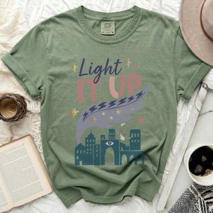 Green t-shirt with "Light It Up" text and cityscape design.