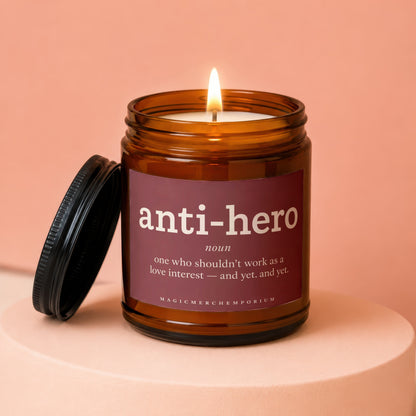 Amber candle with "anti-hero noun" definition on label.