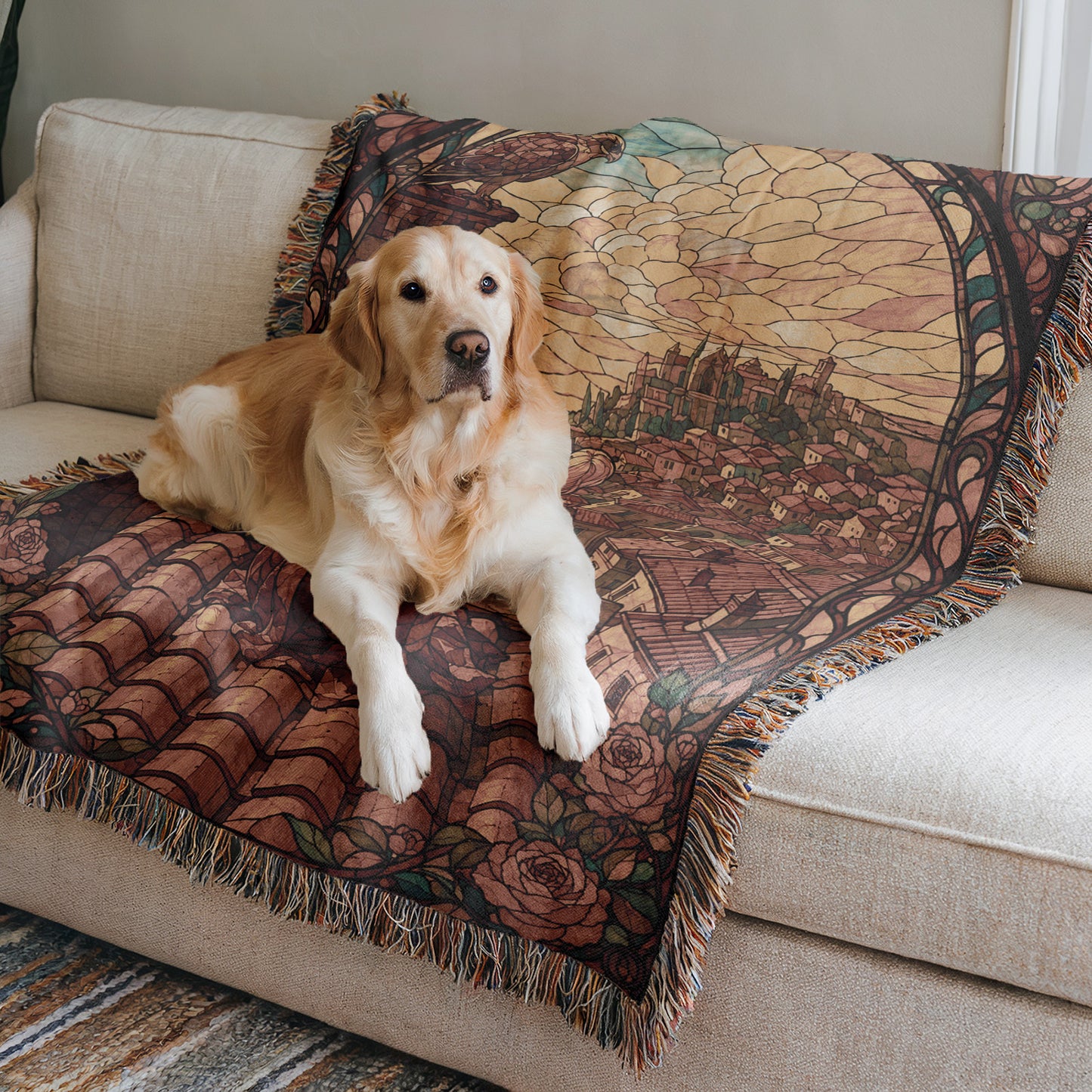 A golden retriever dog is lying on a couch with a colorful, patterned blanket featuring a castle or palace design.