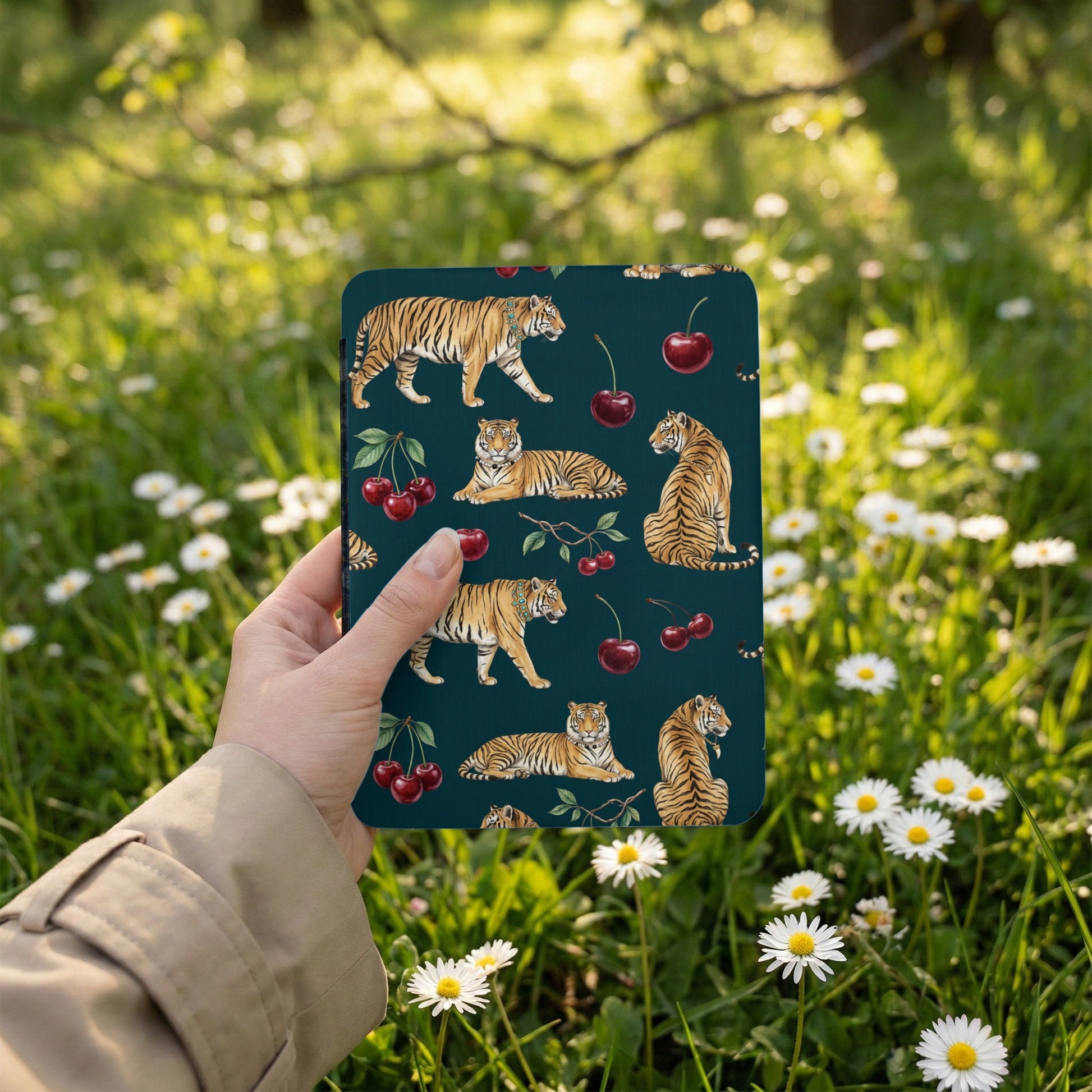 Dark green pattern with tigers and cherries held by a hand in a garden.