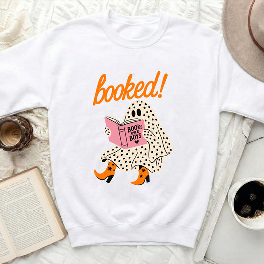 White sweatshirt with a ghost reading "Books Over Boys" and "booked!" text.