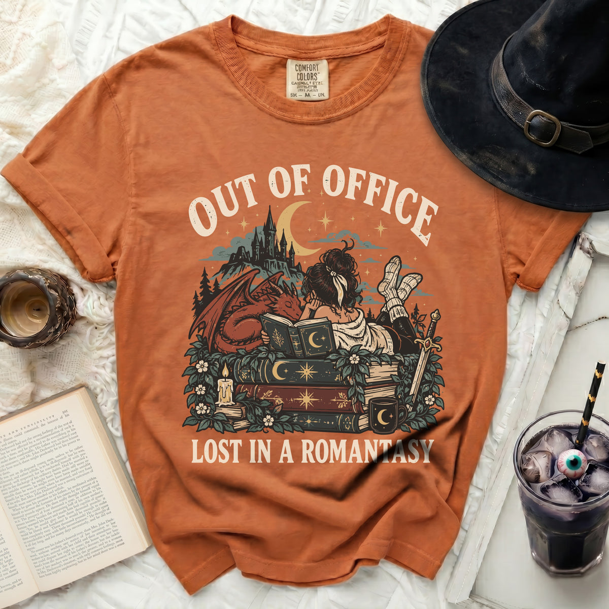 Orange t-shirt with "OUT OF OFFICE LOST IN A ROMANTASY" graphic.