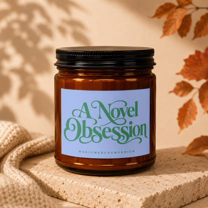 Amber jar candle labeled "A Novel Obsession" with "MagicMerchEmporium" below.